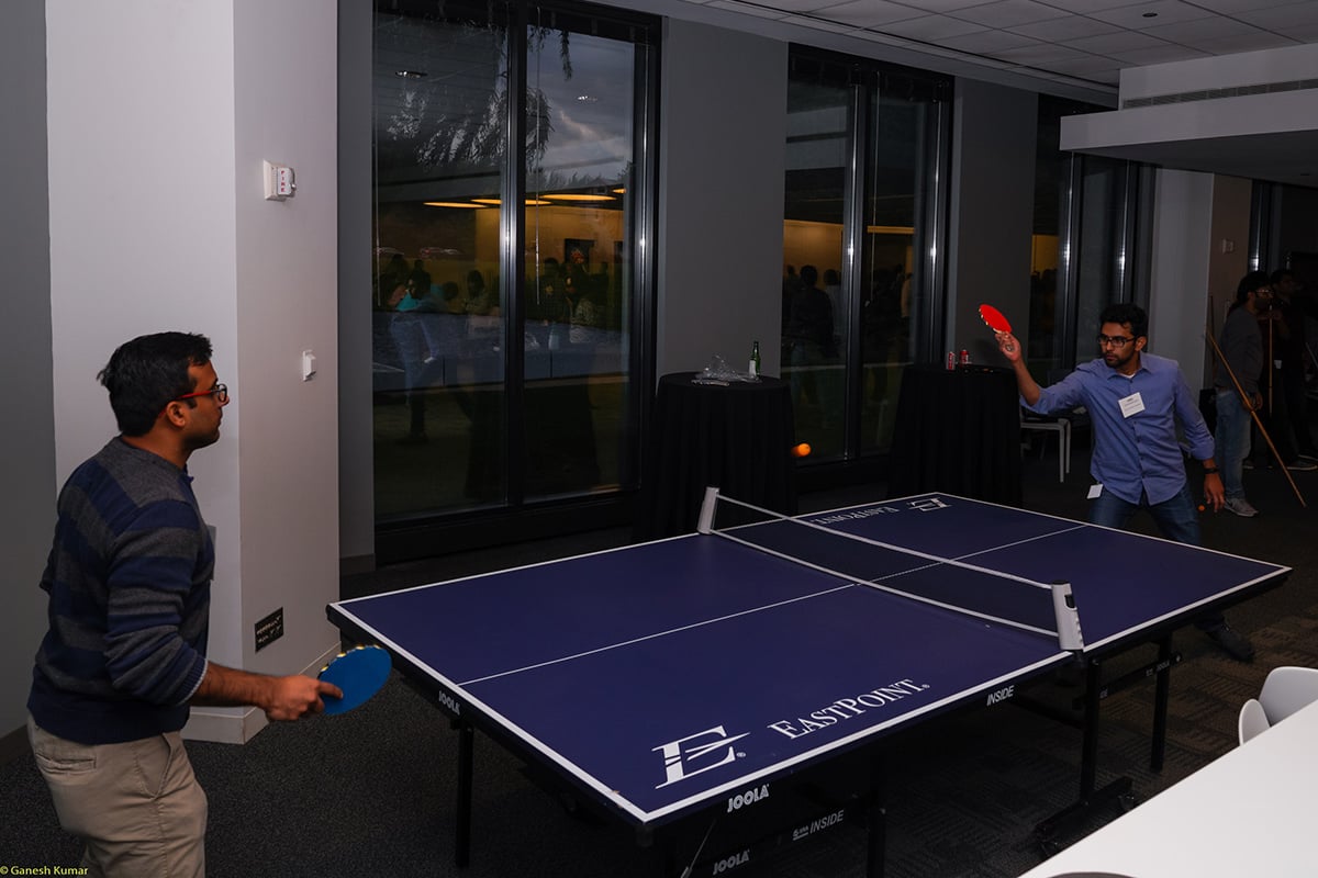 CSC Corptax coworkers playing ping pong in the office