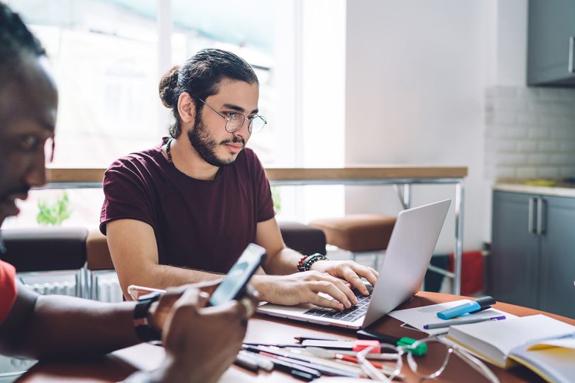 Diligent employee in glasses and casual clothes working on a laptop