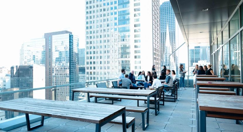 Photo of outdoor balcony area with tables and people gathered in distance