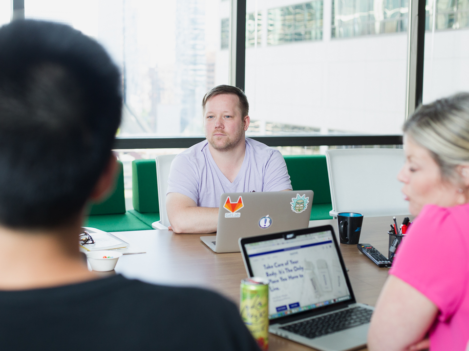 Brant sits with his coworkers at a conference table