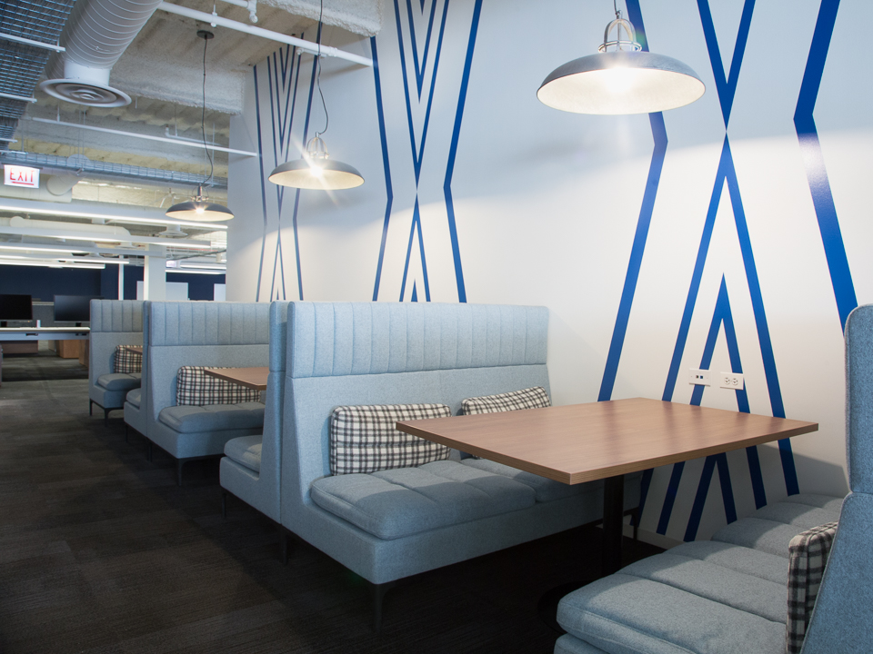 blue cushioned booths against blue and white wallpaper