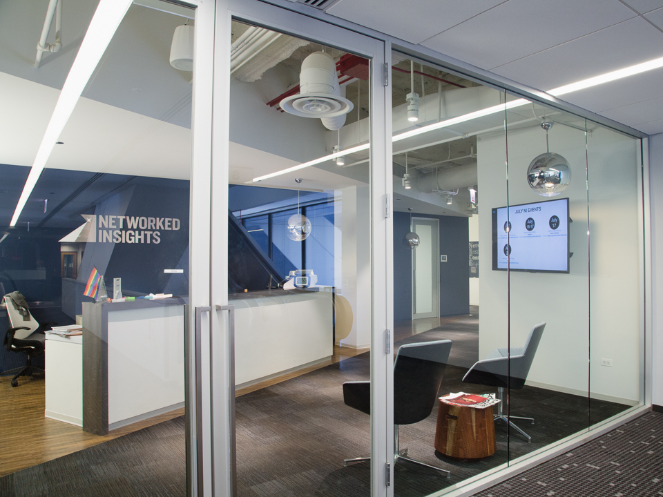 view of the welcome desk at Networked Insights from behind glass doors