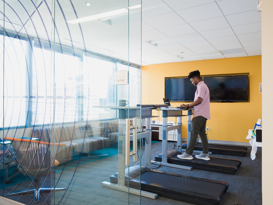 man in office walking on treadmill desk