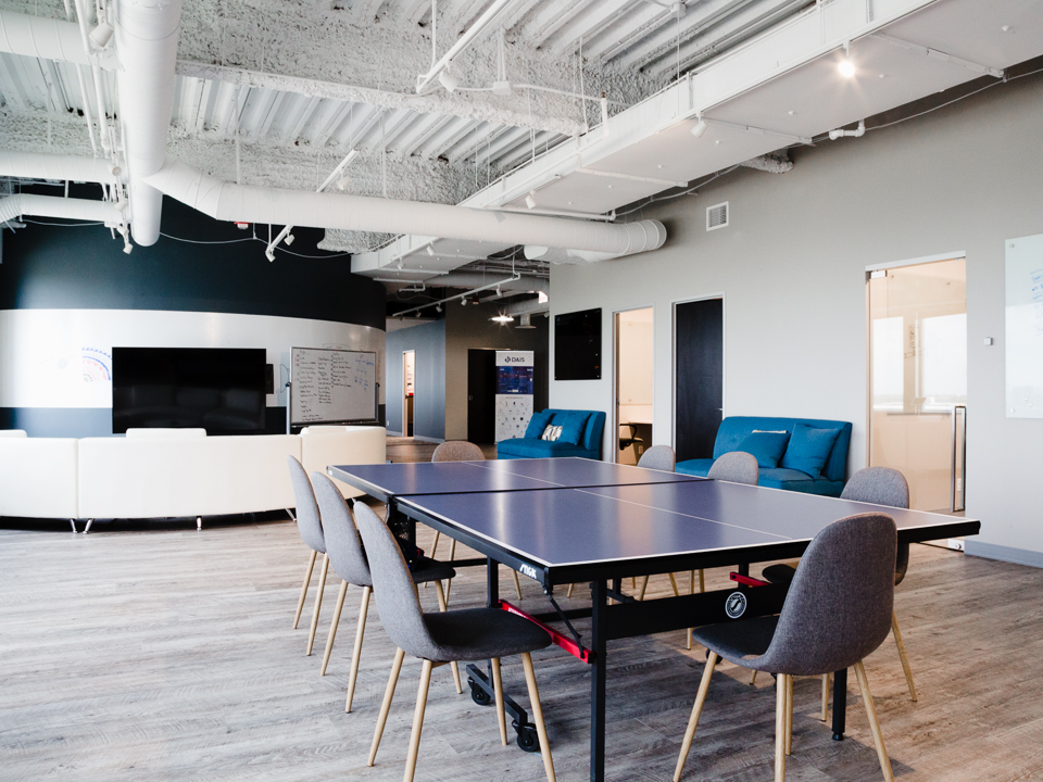 A ping pong table in the DAIS office with chairs surrounding it