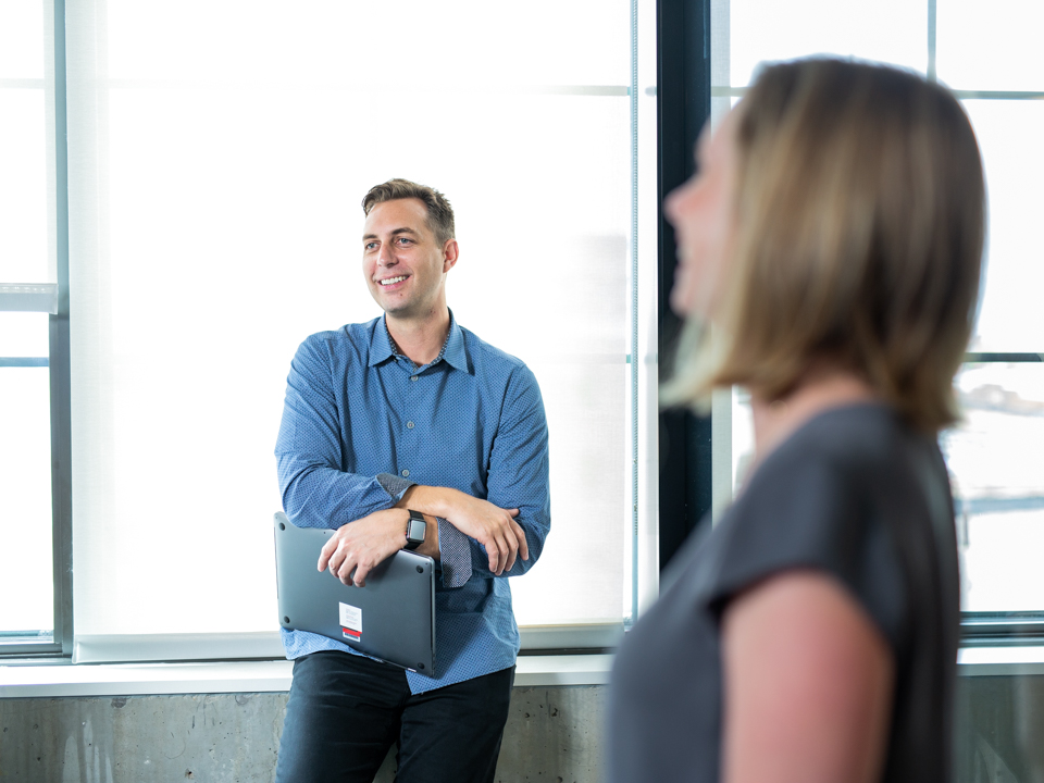 ServiceNow's Joe Davis holding is laptop and smiling