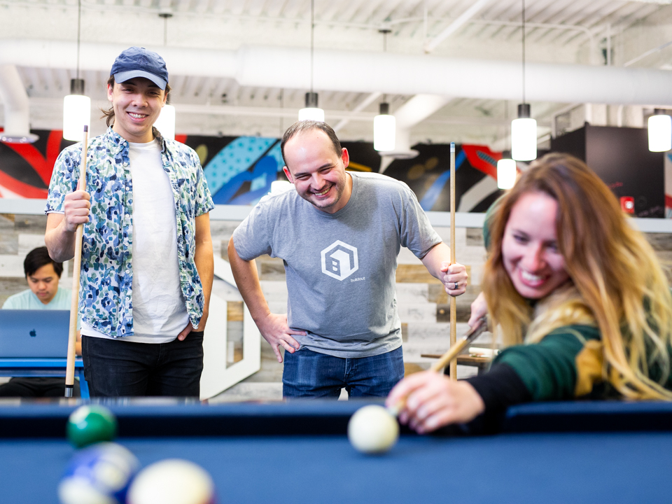 Buildout team members playing billiards in the company game room