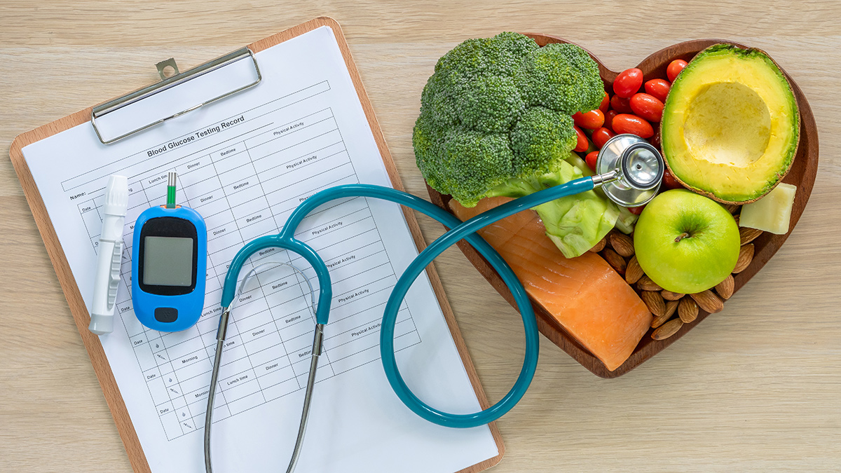 Fruits and vegetables in a heart shaped bowl with a stethoscope and medical report