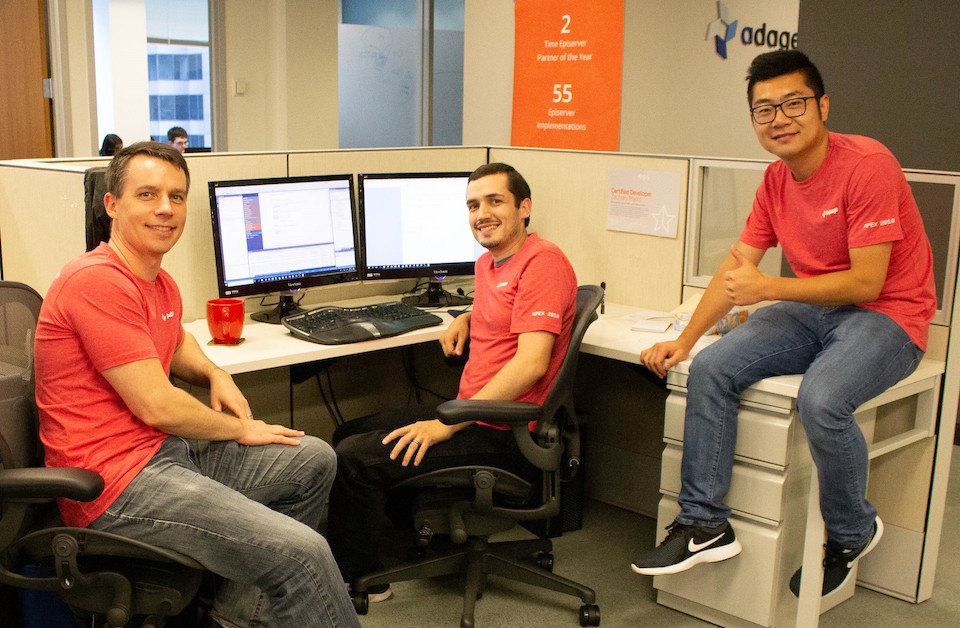 Three leaders from Adage Technologies pictured in a cubicle