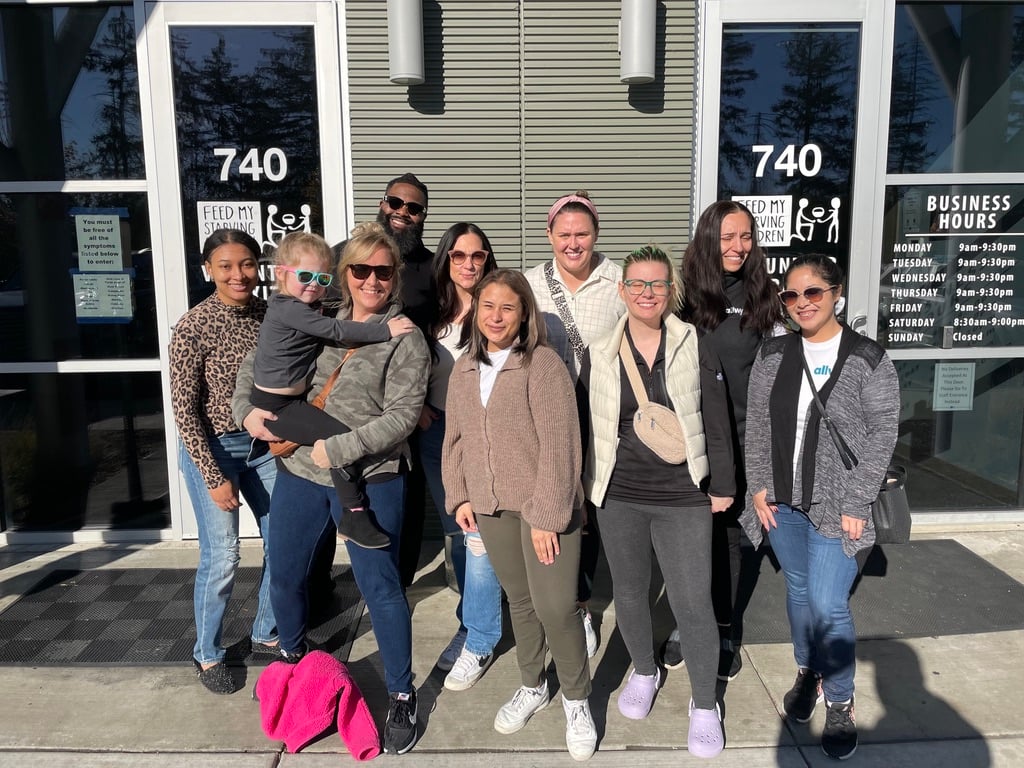 Rodriguez and other Allwyn North America employees pose in the sun outside of a Feed My Starving Children office.