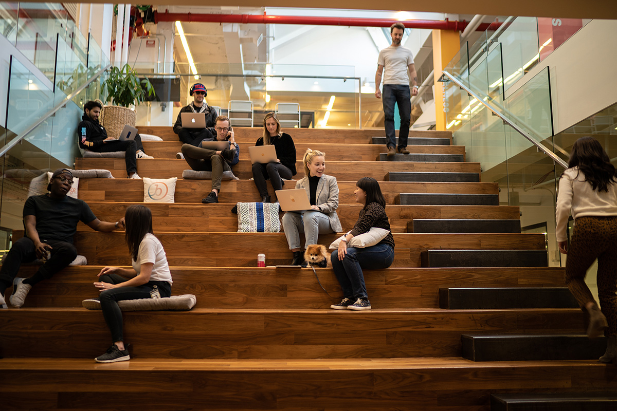 Braze team members sitting on tiered bleacher seating in the office