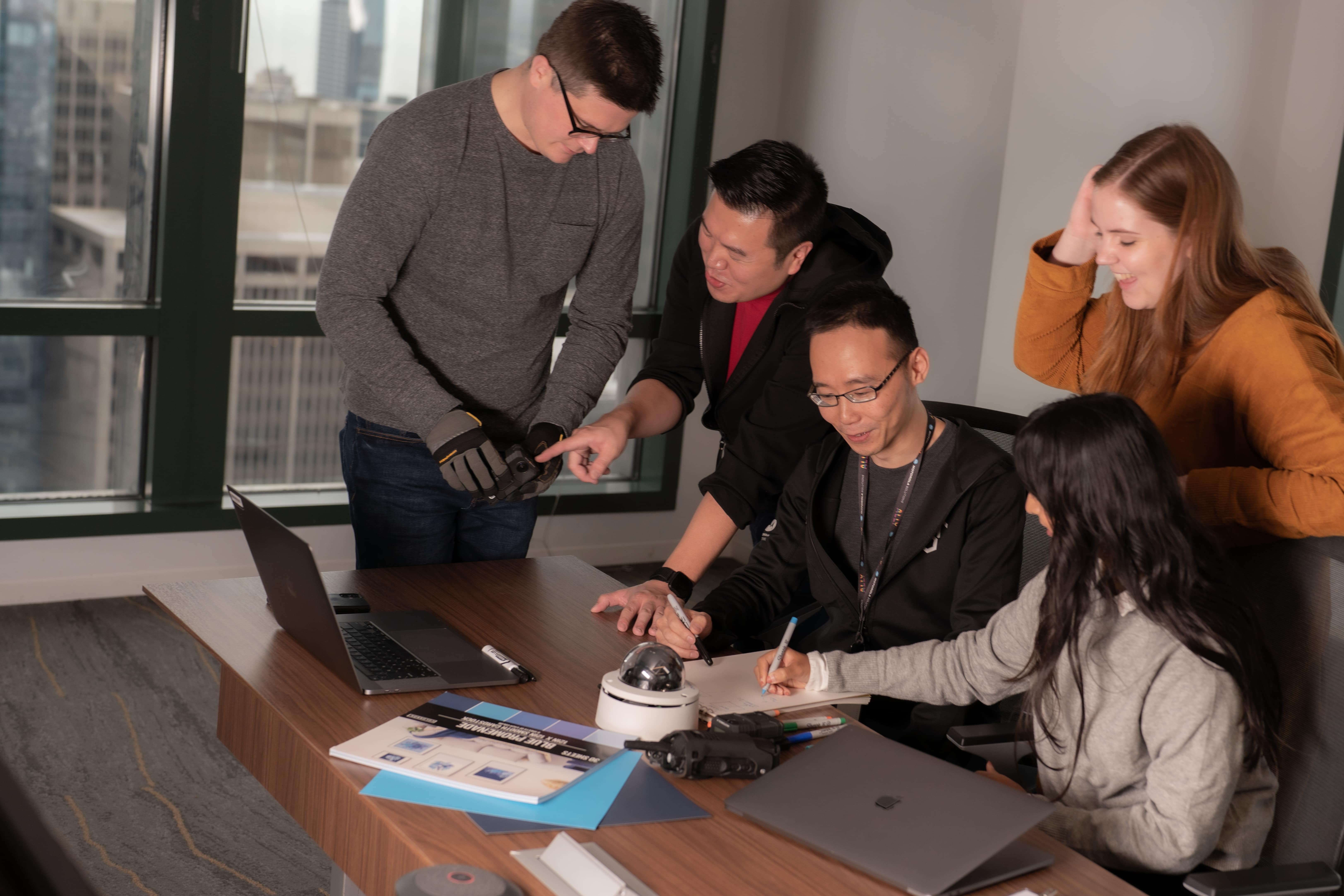 Five of Motorola Solutions' team members sitting around a table and planning.