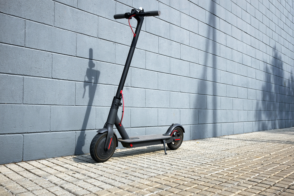 Electric scooter against a blue brick wall
