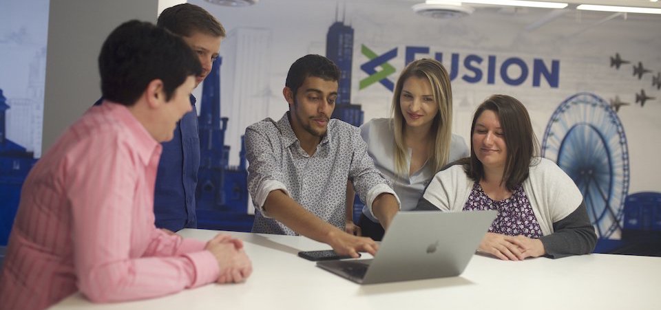 Fusion Risk Management team members working on a laptop