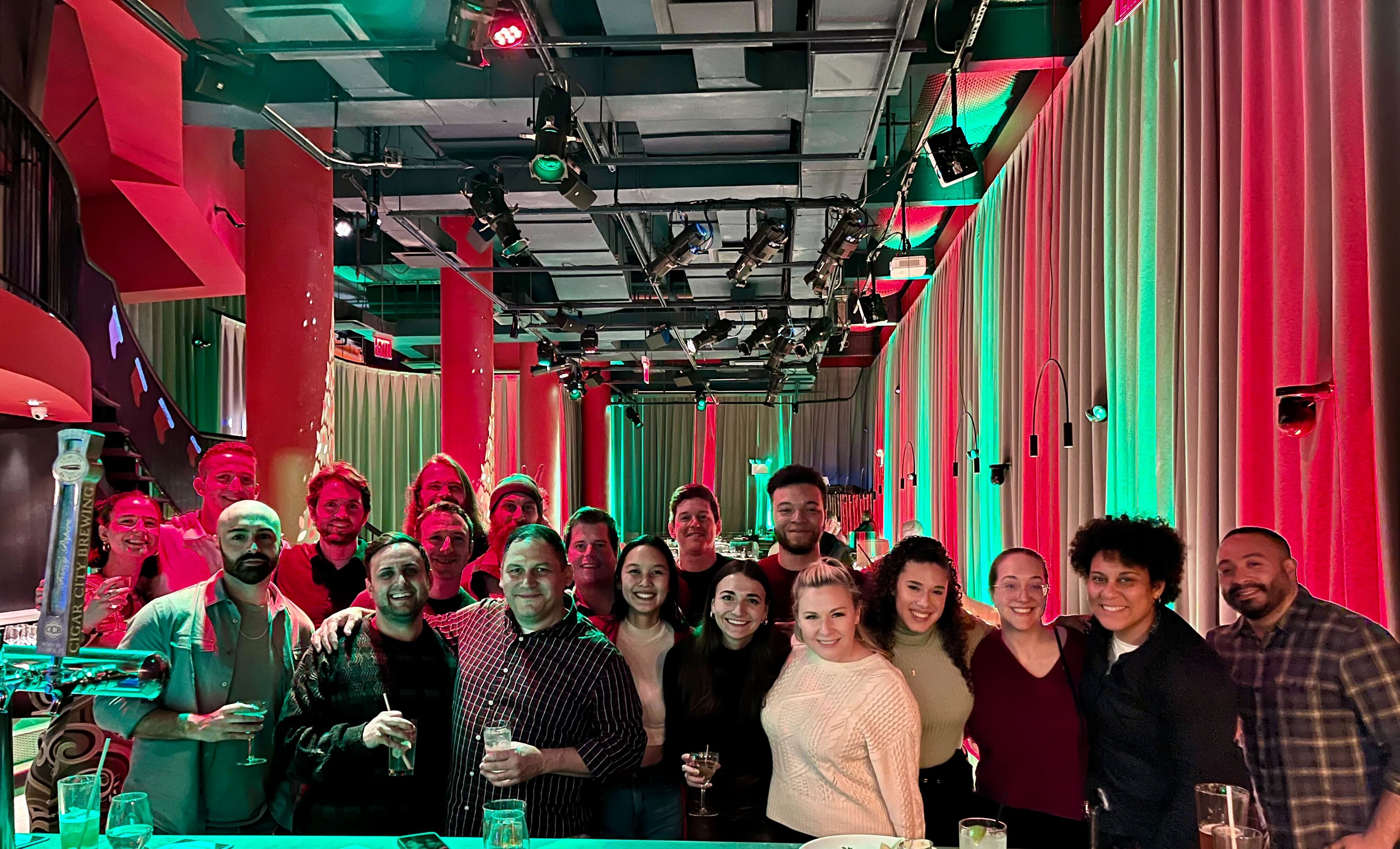 The Instawork team at a party lit with red and green light