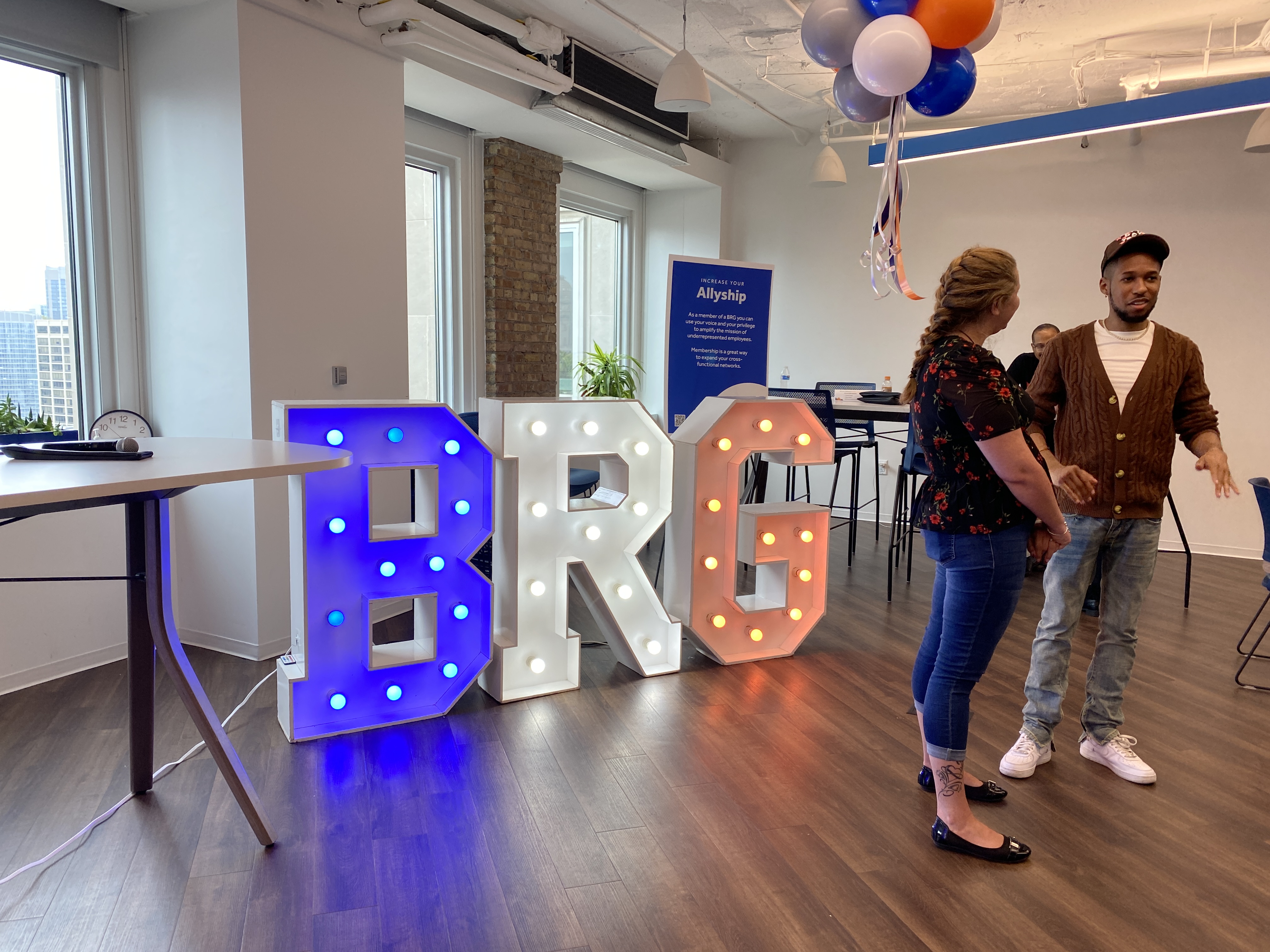  Large letters reading “BRG” inside OppFi’s office signify a business resource group event, with team members standing nearby.