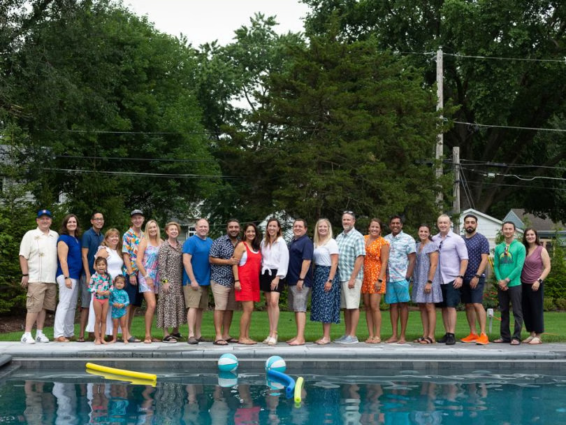A group of Inspirant employees pose by a pool.