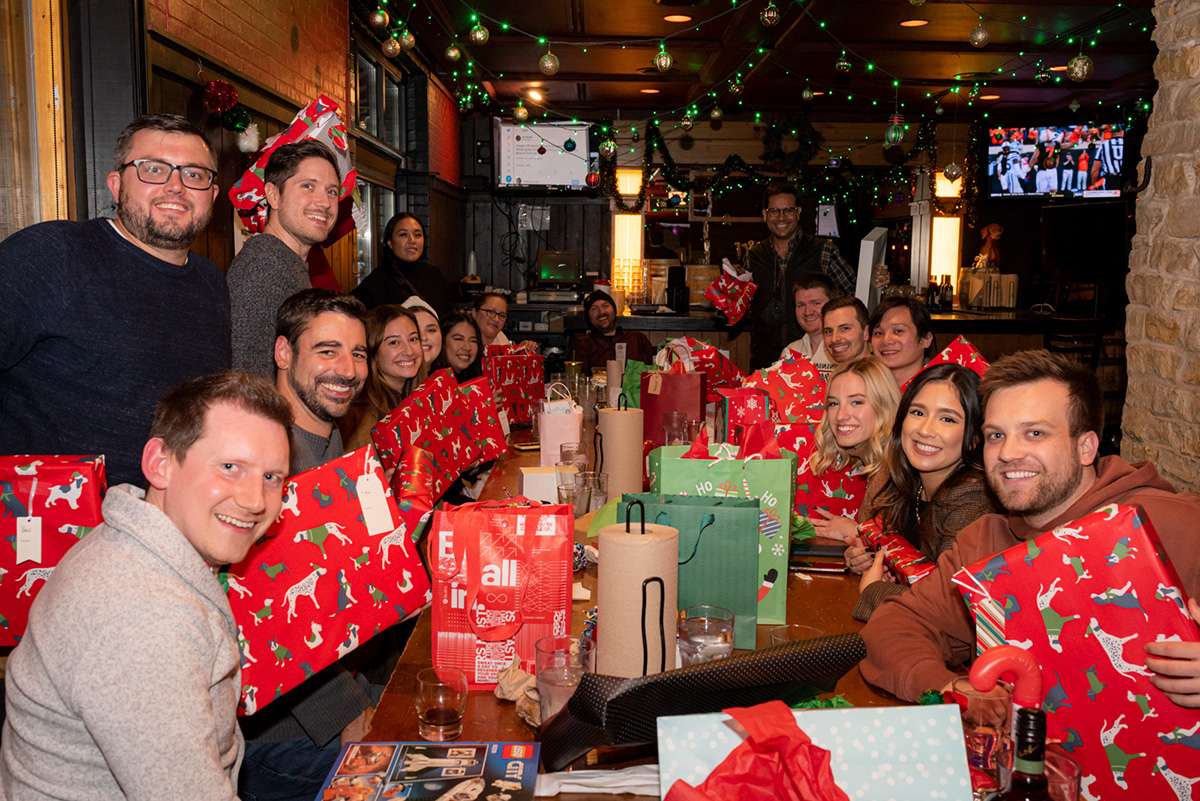 Marcel team members at a holiday party exchanging gifts