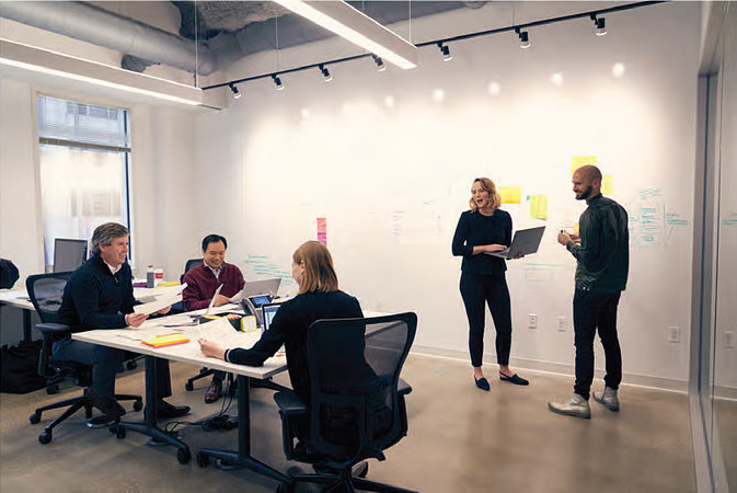 A group of Northern Trust employees work in the office.