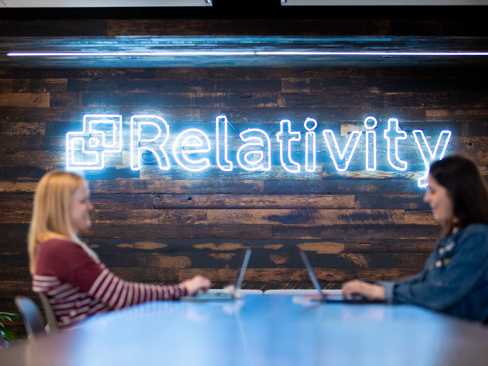 Relativity logo and two female employees working