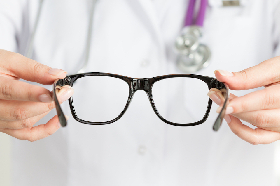 Doctor holds a set of spectacles up to the camera