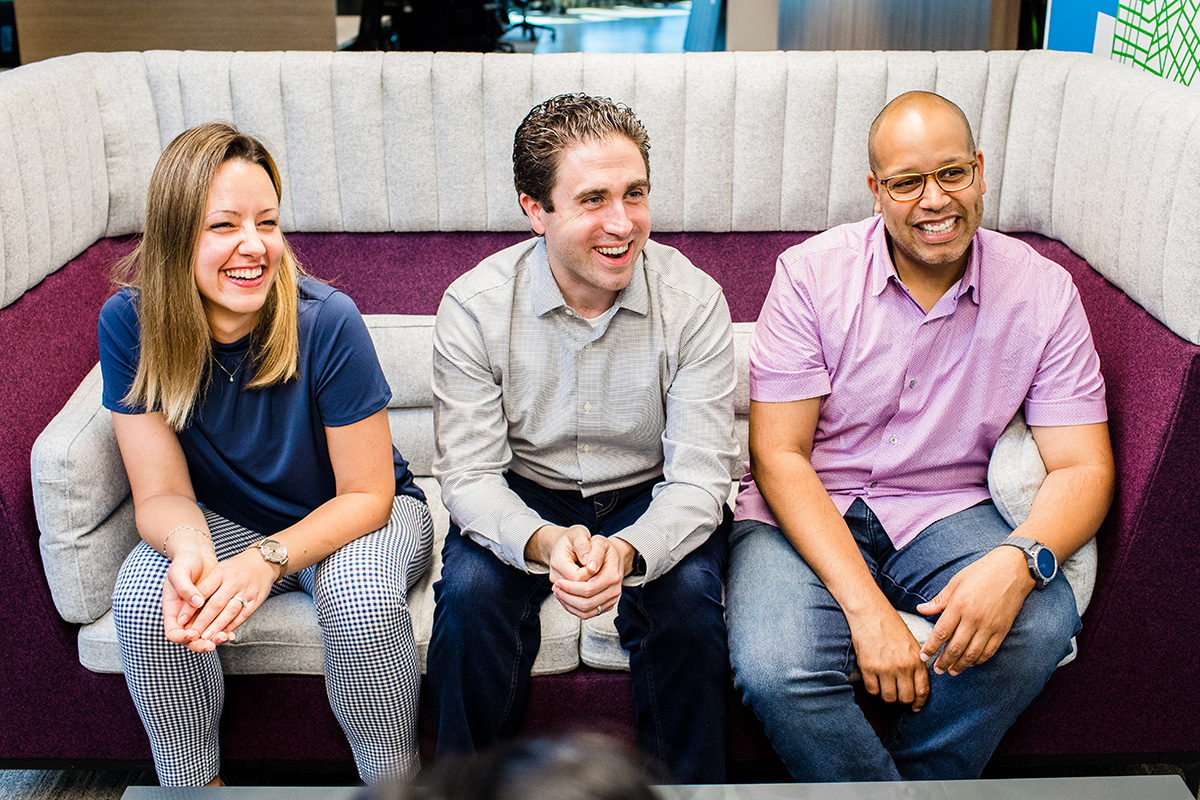 Three Peapod team members sitting on a couch smiling