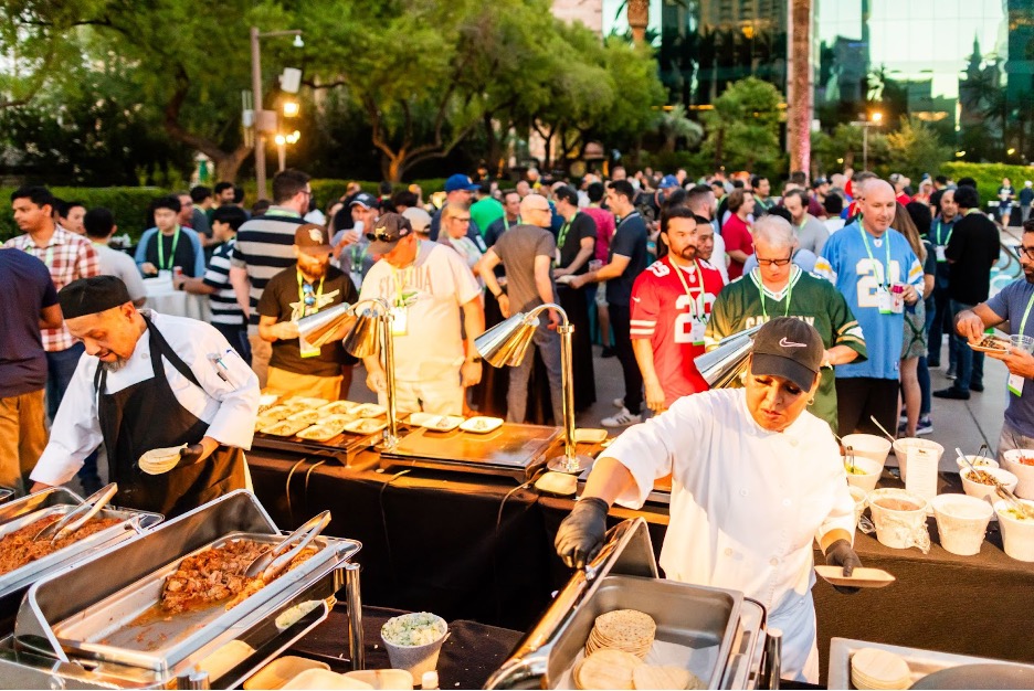 An outdoor food station at UTG Connect with cooks prepping food for a crowd of ServiceNow employees.