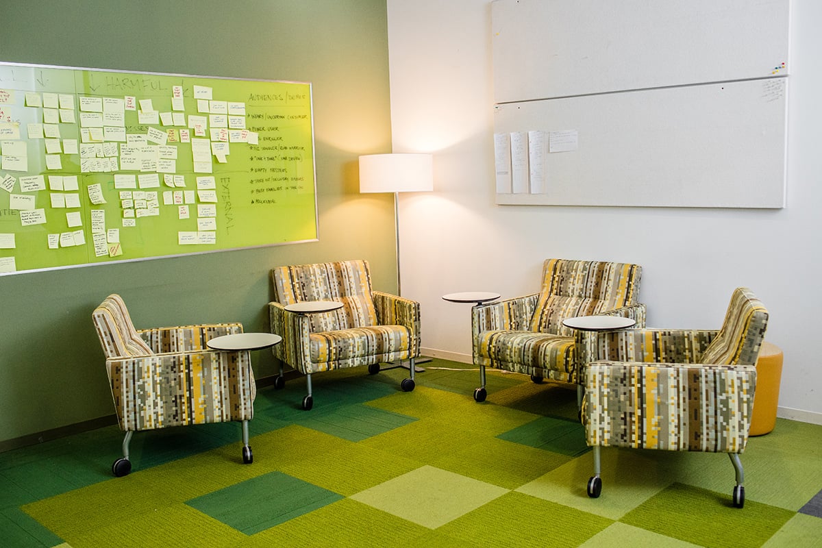 Meeting area in the Rewards Network office with green striped chairs and a dry erase board with notes on it