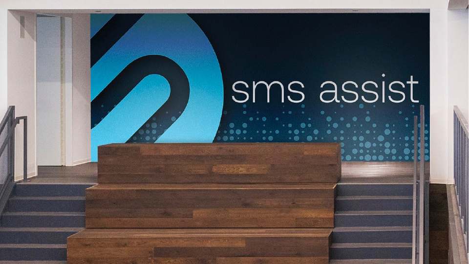 SMS Assist logo on the wall in the office