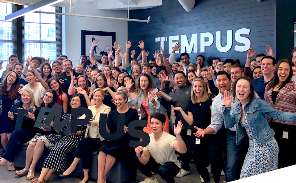 Tempus staff smiling and waving in office