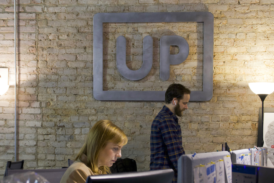 UPshow logo in their office with staff pictured