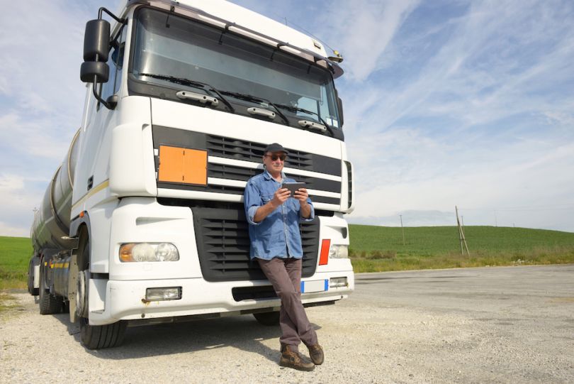 Man using photo in front of big rig