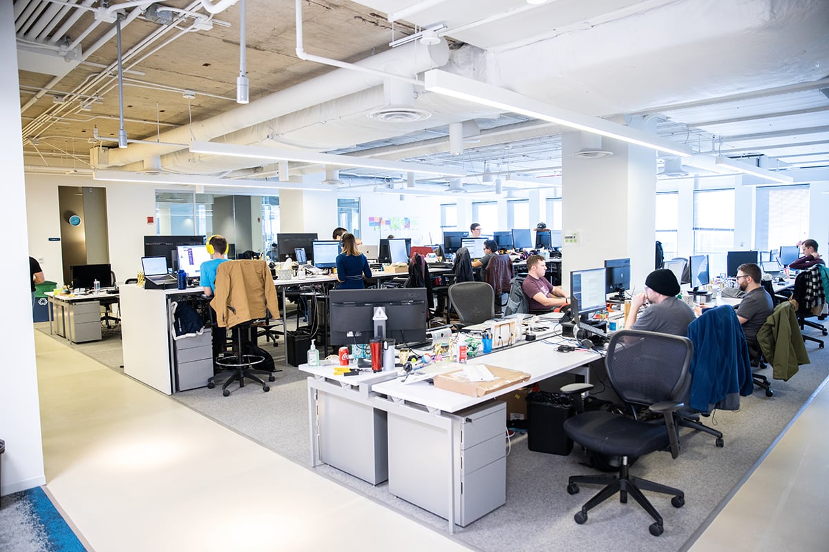 Yello team members sitting at desks in an open concept office.