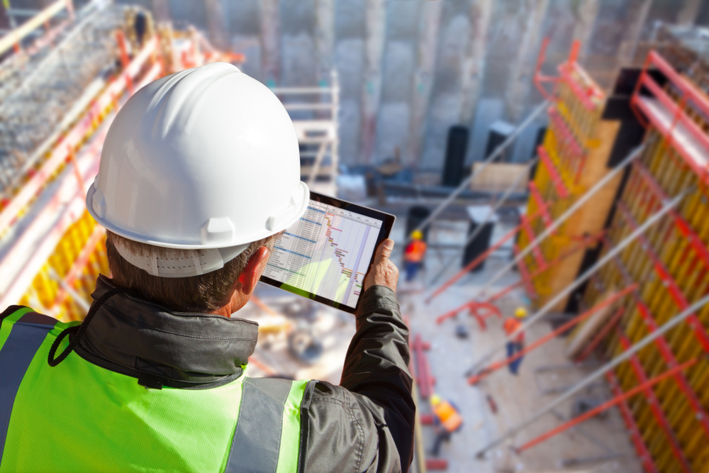 Construction worker uses tablet on skyscraper - Zebra Technologies
