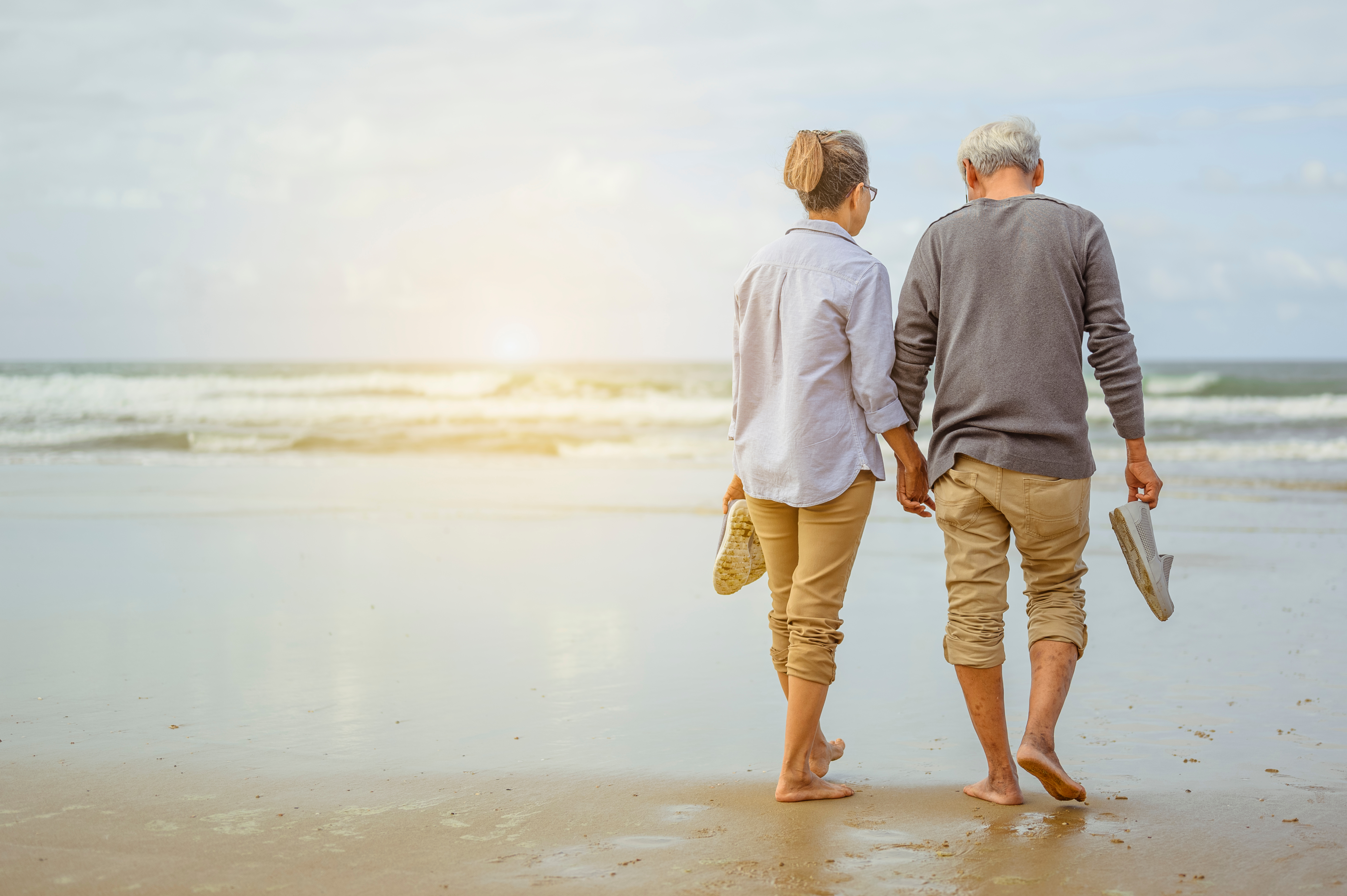 retired couple walking beach