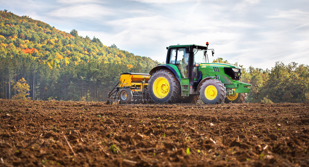 A John Deere tractor plowing a field