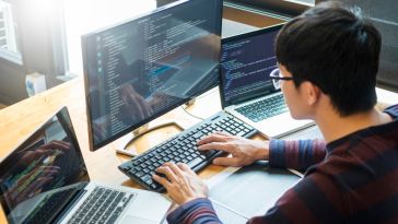  programmer working on a desktop computer programming code technologies