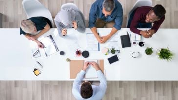 Overhead view of a diverse group of peopel sitting at a conference table