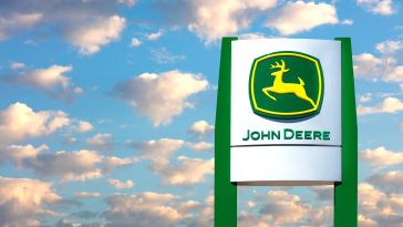 An image of a John Deere sign against a blue sky.