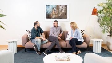 Muammer Akgün, Erhan Musaoglu and Elizabeth Walsh site on a couch in Logiwa’s office, talking
