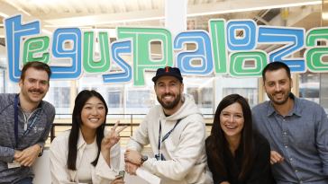 Tegus employees stand in front of a "Teguspalooza" sign