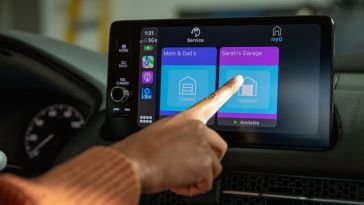 A driver uses a touchscreen app to manipulate their garage door.