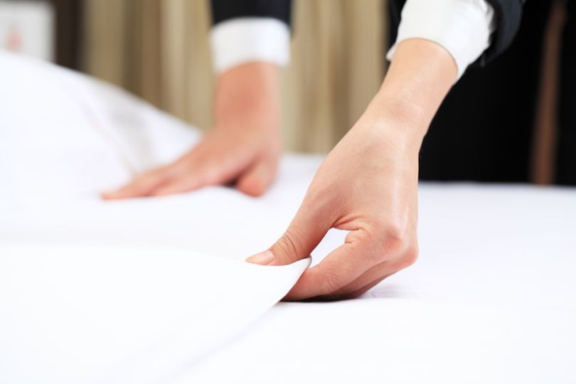 The Minte — woman fixing a bedspread