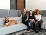 three mastery logistics employees sitting on couch with dog
