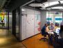 BCG X office space with glass walls into conference room where people are meeting